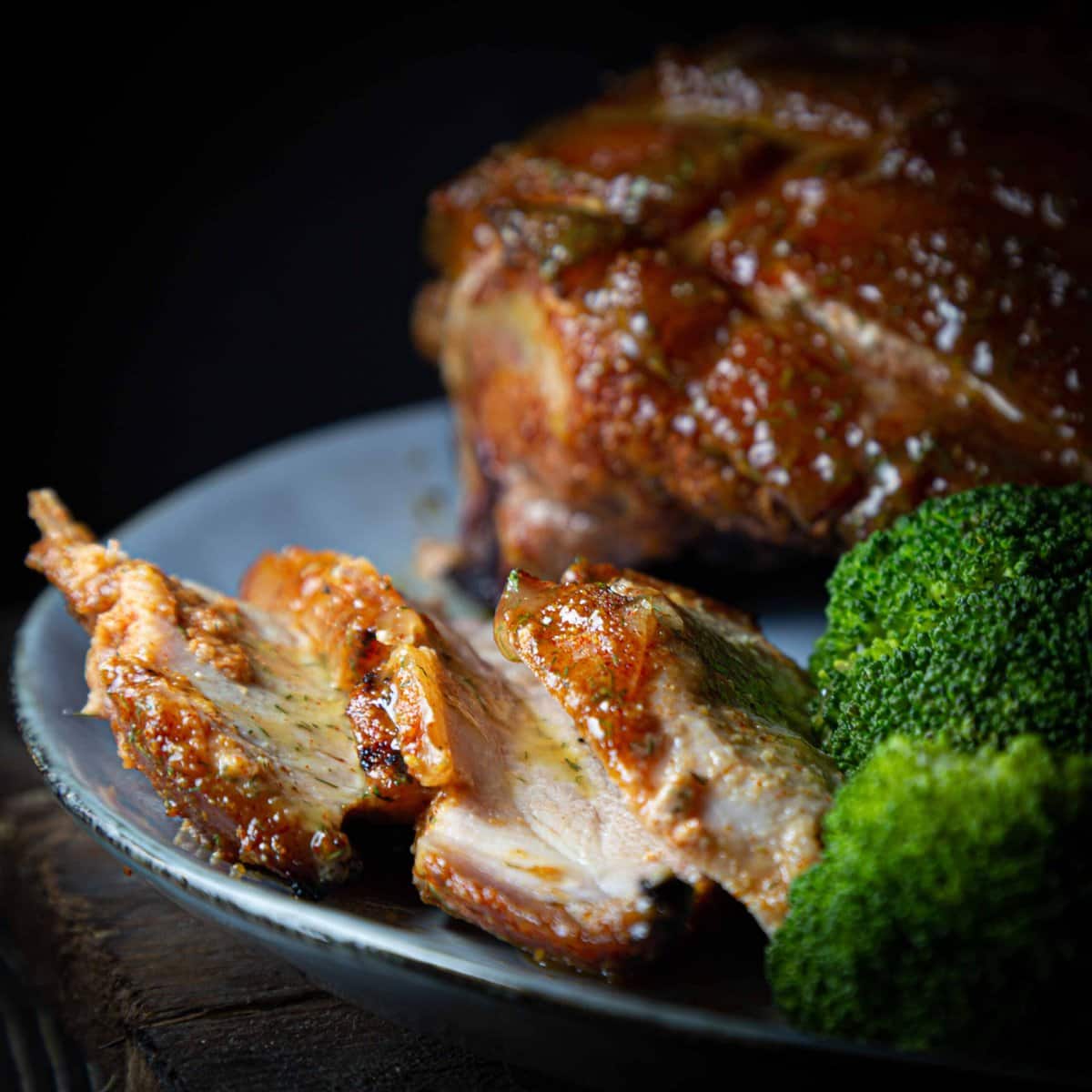 gerookte beenham met mosterd honing dille saus en broccoli op een bord